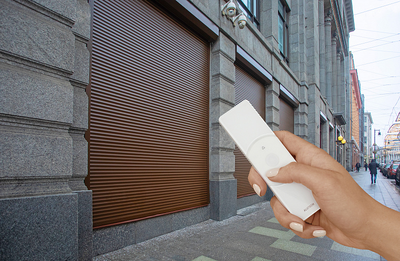 пульт управления роллетными воротами на фоне роллетных ворот